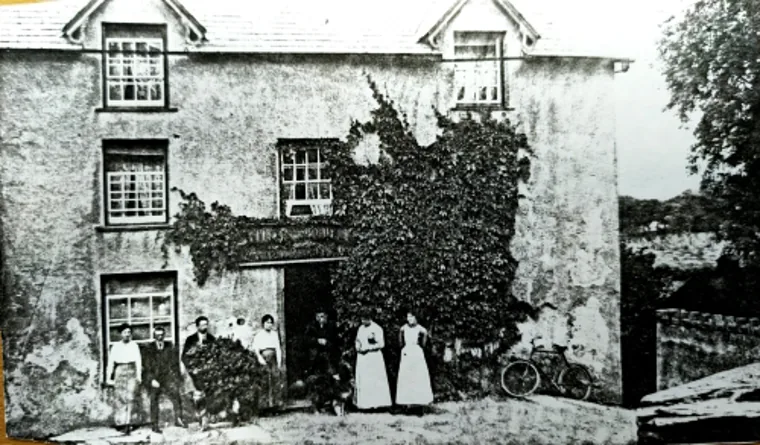 The pub building in an early photograph, with people standing outside