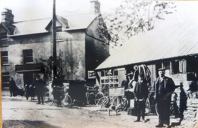 A street scene in Talsarnau in years past, with figures and bicycles